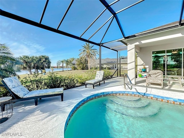 view of pool with glass enclosure, a water view, and a patio