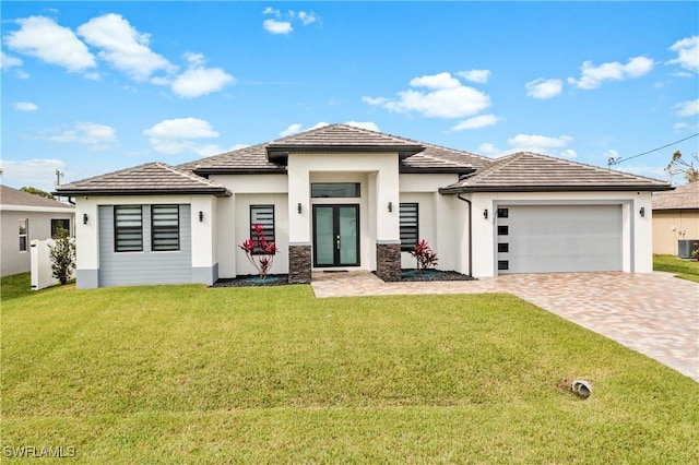 prairie-style home featuring a garage, french doors, and a front lawn