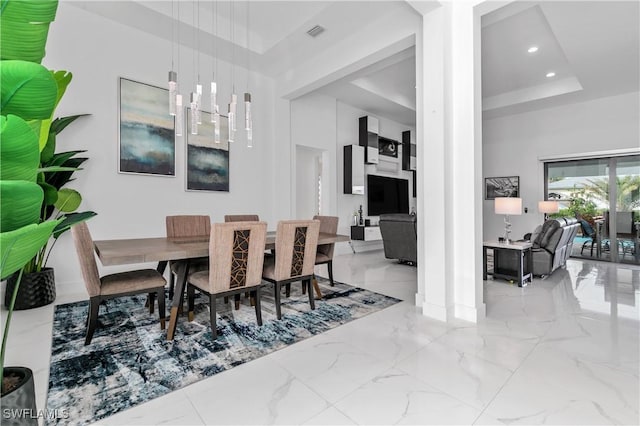 dining room with a towering ceiling and a tray ceiling