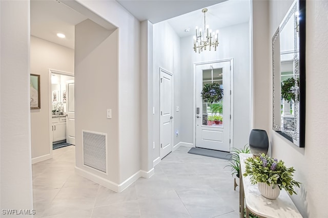 entryway with a chandelier and light tile patterned flooring