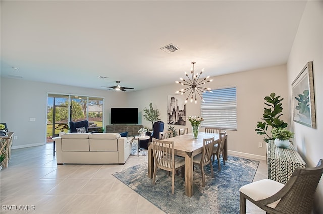 dining room with ceiling fan with notable chandelier and light tile patterned floors