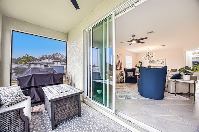 balcony with grilling area, an outdoor fire pit, ceiling fan, and a patio area