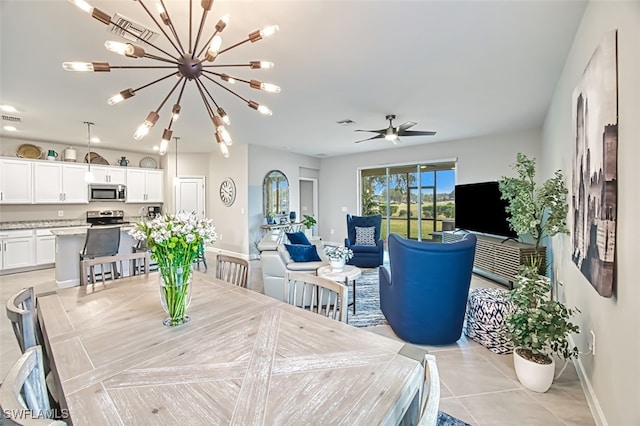 dining area with light tile patterned flooring and ceiling fan with notable chandelier