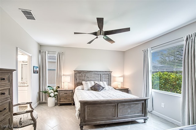 bedroom featuring ceiling fan, ensuite bath, and light tile patterned floors