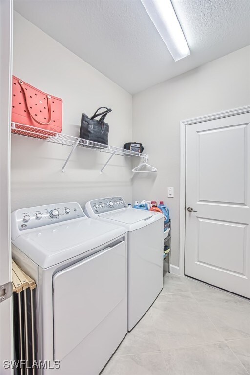 laundry room with washing machine and dryer and a textured ceiling