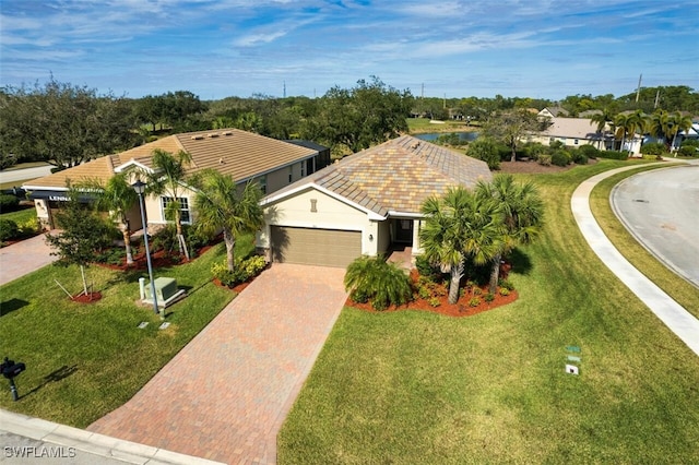 view of front of house with stucco siding, an attached garage, decorative driveway, and a front yard