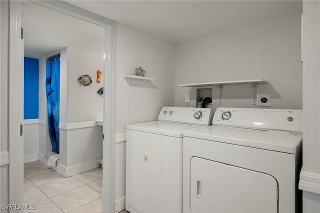 washroom featuring light tile patterned flooring and washing machine and clothes dryer