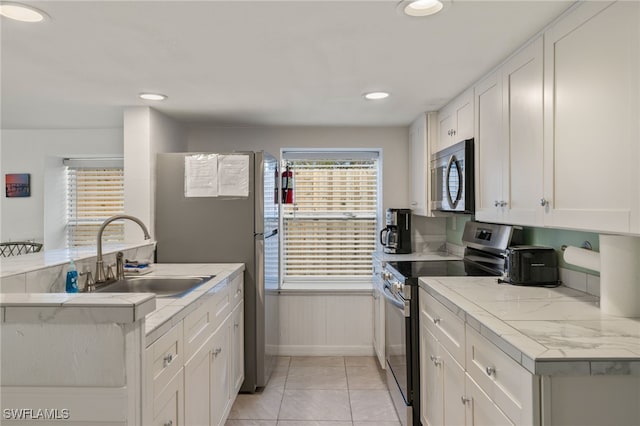 201 Miramar St, Fort Myers Beach, FL 33931 - kitchen featuring a sink, stainless steel appliances, light tile patterned flooring, white cabinetry, and light countertops