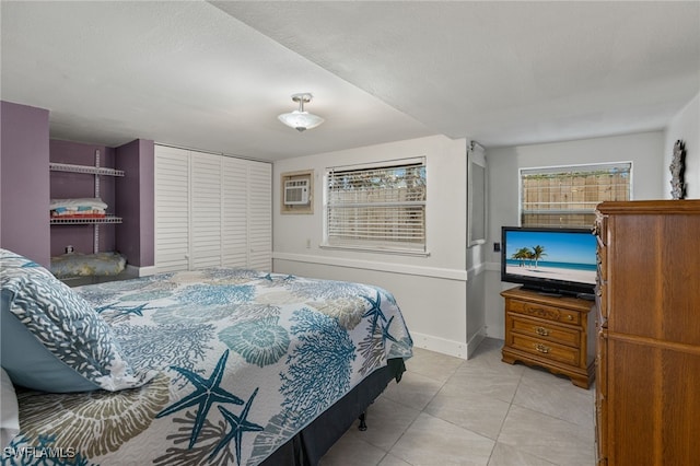 tiled bedroom with a closet, an AC wall unit, and a textured ceiling