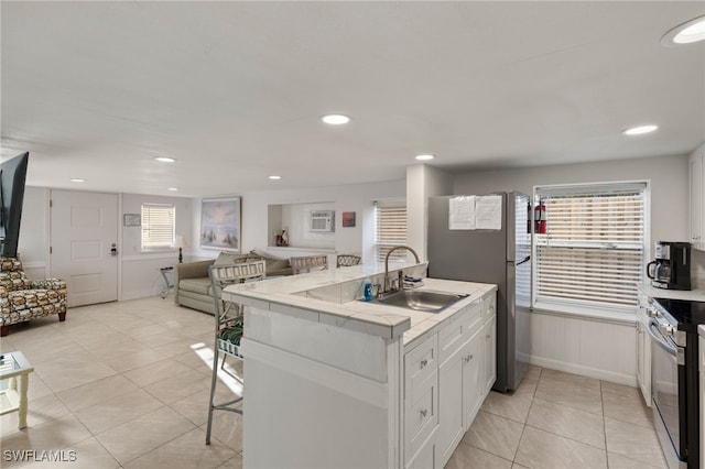 kitchen featuring stainless steel appliances, plenty of natural light, sink, and white cabinets