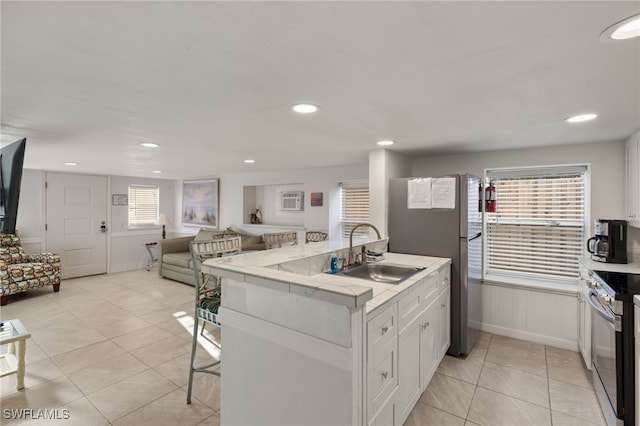 201 Miramar St, Fort Myers Beach, FL 33931 - kitchen featuring a breakfast bar area, white cabinets, a sink, appliances with stainless steel finishes, and light countertops