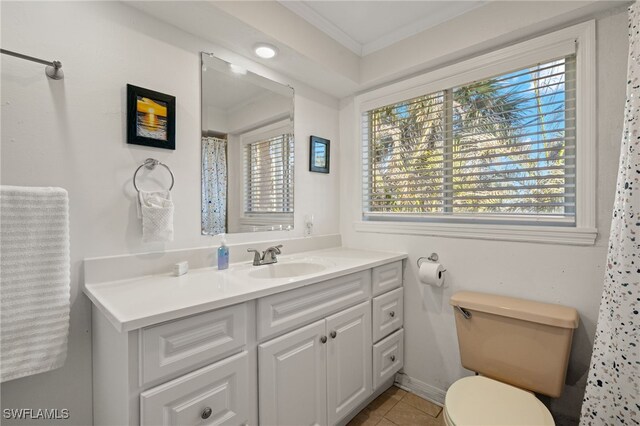 bathroom featuring tile patterned flooring, vanity, crown molding, and toilet