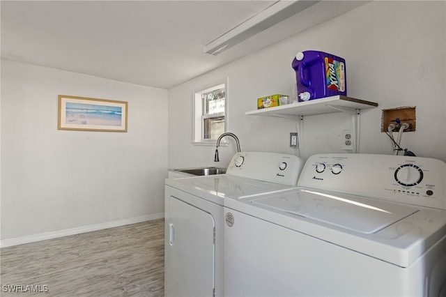 laundry area with independent washer and dryer, sink, and light wood-type flooring