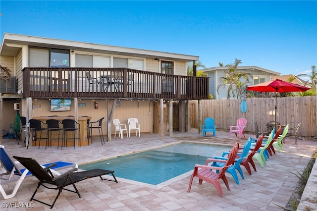 view of pool with an outdoor bar and a patio