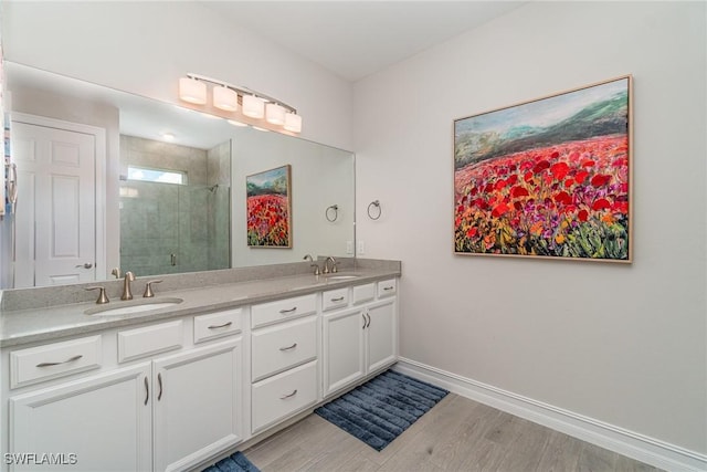 bathroom featuring wood-type flooring, vanity, and a shower with shower door