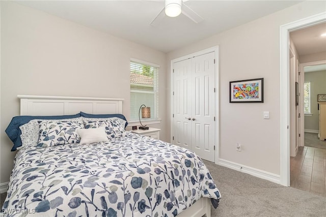 carpeted bedroom with ceiling fan and a closet