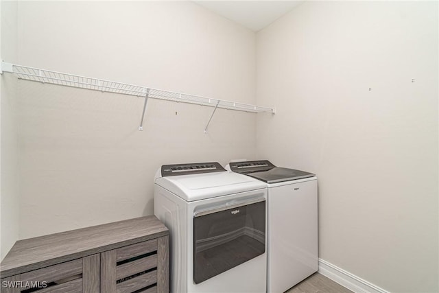 laundry room with light hardwood / wood-style floors and independent washer and dryer