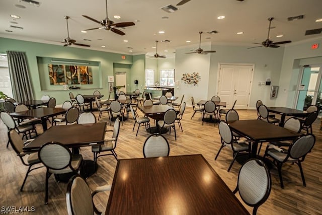 dining space with crown molding, a healthy amount of sunlight, and light wood-type flooring