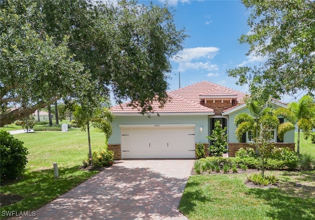 mediterranean / spanish home with a front lawn and a garage