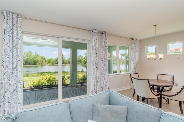 interior space featuring a water view, a healthy amount of sunlight, and a notable chandelier