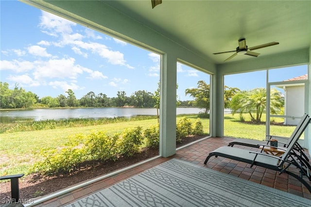 sunroom with ceiling fan, a water view, and a wealth of natural light