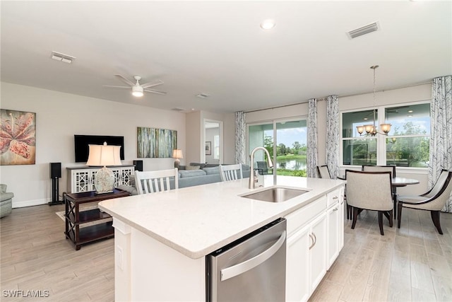 kitchen with white cabinetry, sink, stainless steel dishwasher, decorative light fixtures, and a center island with sink