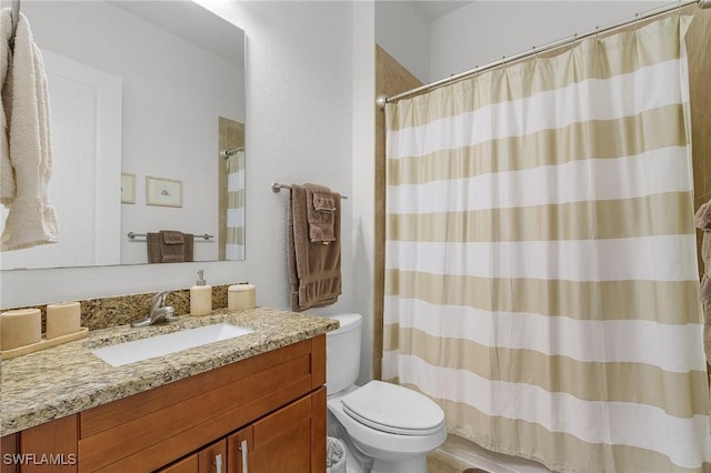 bathroom featuring curtained shower, vanity, and toilet