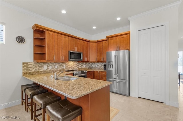 kitchen featuring sink, light stone countertops, ornamental molding, kitchen peninsula, and stainless steel appliances