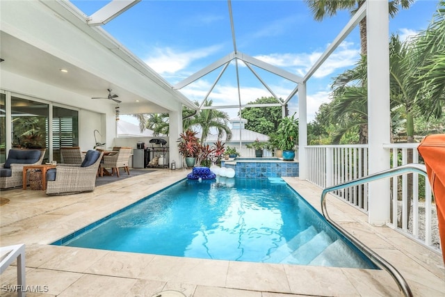 view of pool with an in ground hot tub, glass enclosure, ceiling fan, and a patio area