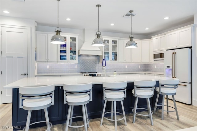 kitchen with a large island, white cabinetry, white appliances, and custom exhaust hood