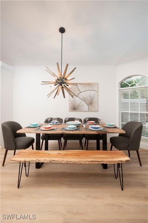 dining area featuring light wood-type flooring and an inviting chandelier