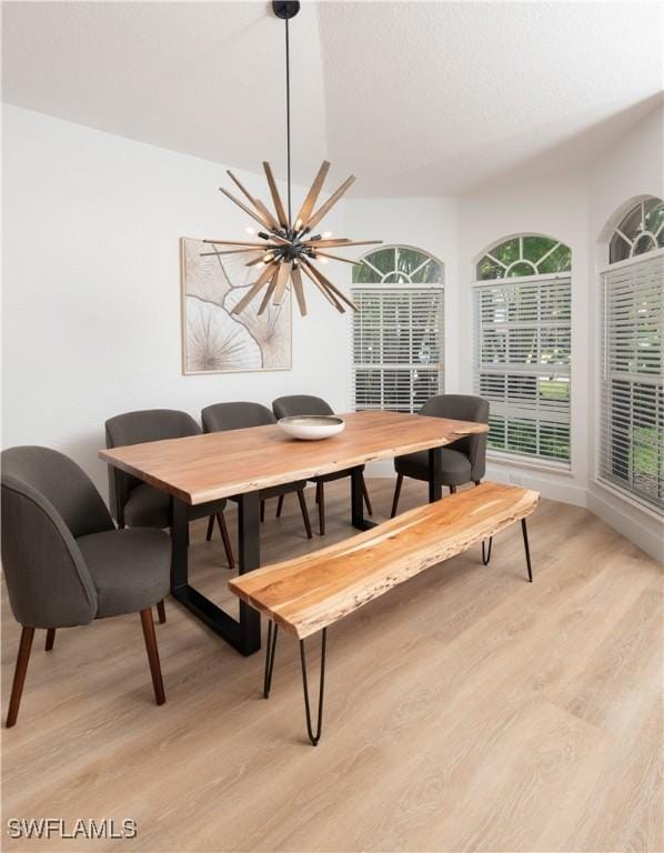 dining space with an inviting chandelier and light hardwood / wood-style flooring