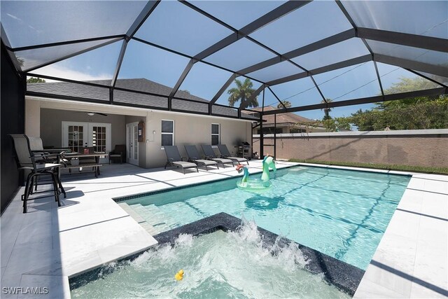 view of pool with french doors, pool water feature, ceiling fan, a lanai, and a patio area