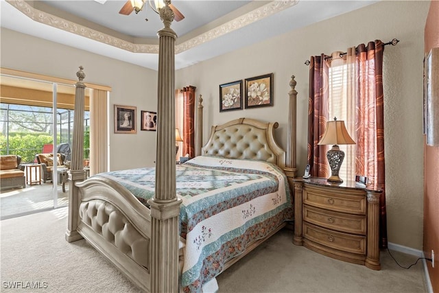 bedroom featuring ceiling fan, light colored carpet, a tray ceiling, and multiple windows