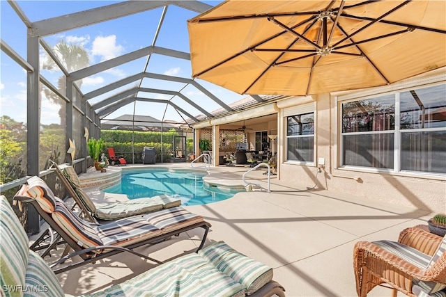 view of swimming pool with ceiling fan, a patio area, and glass enclosure