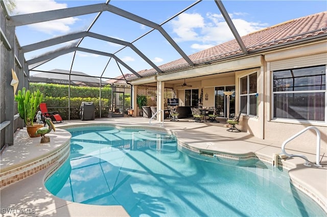 view of swimming pool with a lanai, ceiling fan, and a patio area