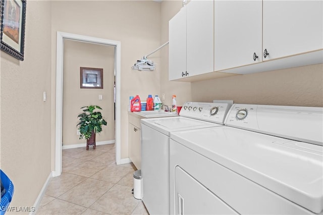 laundry area with sink, washing machine and dryer, light tile patterned flooring, and cabinets