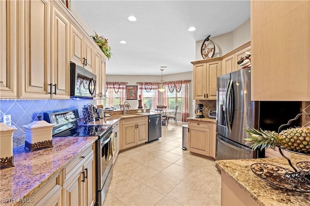 kitchen with light stone counters, pendant lighting, appliances with stainless steel finishes, and tasteful backsplash