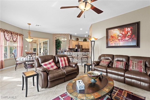 living room featuring ceiling fan with notable chandelier and light tile patterned flooring