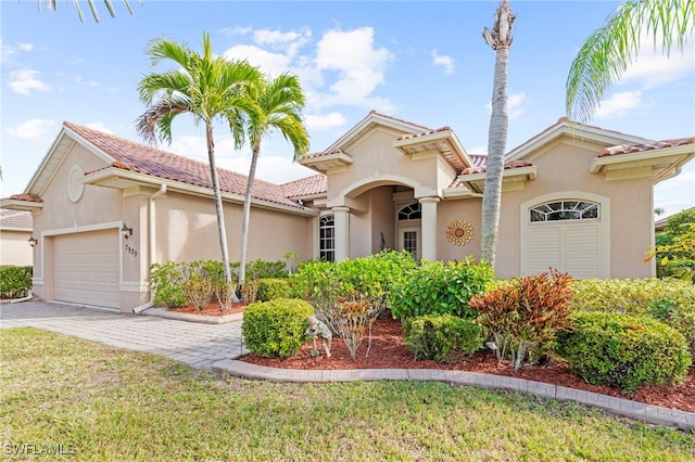 mediterranean / spanish-style home with a front lawn and a garage