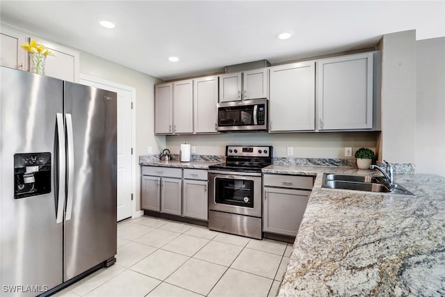 kitchen featuring light stone counters, gray cabinetry, stainless steel appliances, sink, and light tile patterned flooring