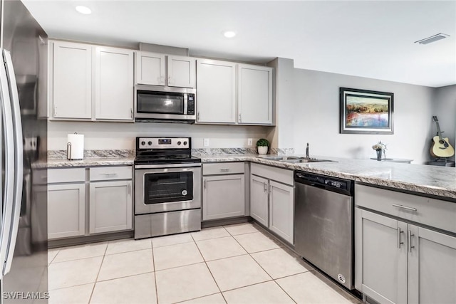 kitchen featuring gray cabinetry, sink, light tile patterned flooring, and stainless steel appliances