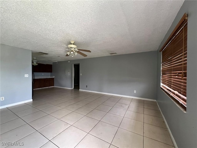 tiled empty room featuring a textured ceiling and ceiling fan