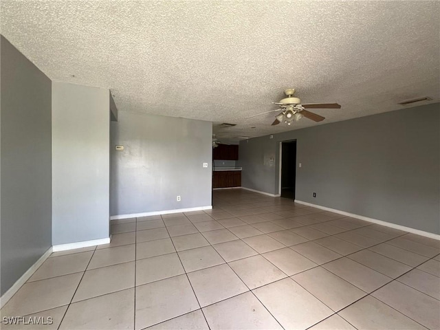 tiled spare room featuring a textured ceiling and ceiling fan