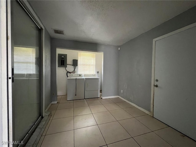 interior space with plenty of natural light, washer and dryer, a textured ceiling, and electric panel