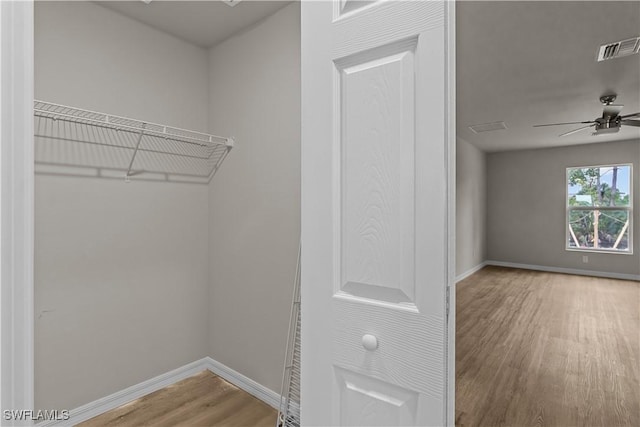 walk in closet featuring ceiling fan and hardwood / wood-style flooring