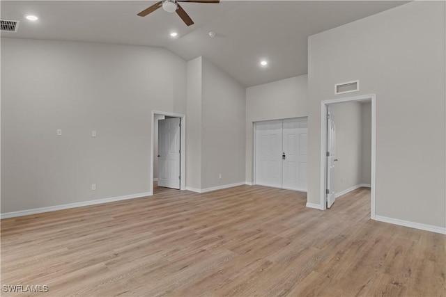 empty room with ceiling fan, light wood-type flooring, and high vaulted ceiling