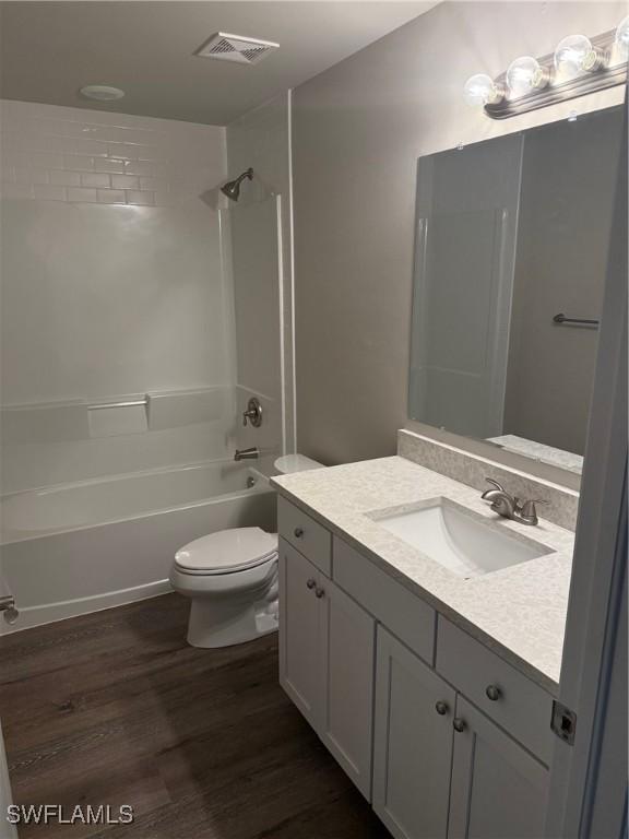 full bathroom with toilet, wood-type flooring, vanity, and bathing tub / shower combination