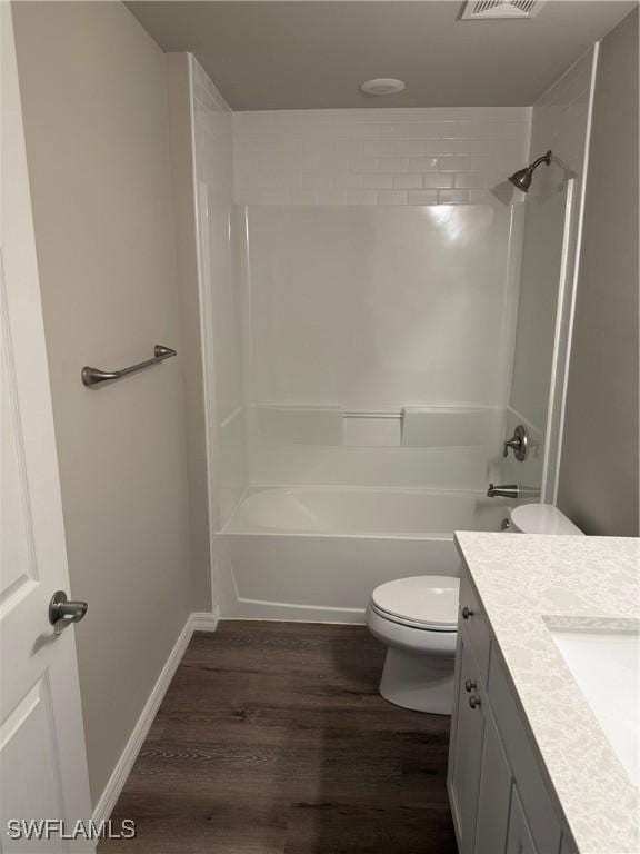 full bathroom featuring toilet, vanity, hardwood / wood-style floors, and washtub / shower combination