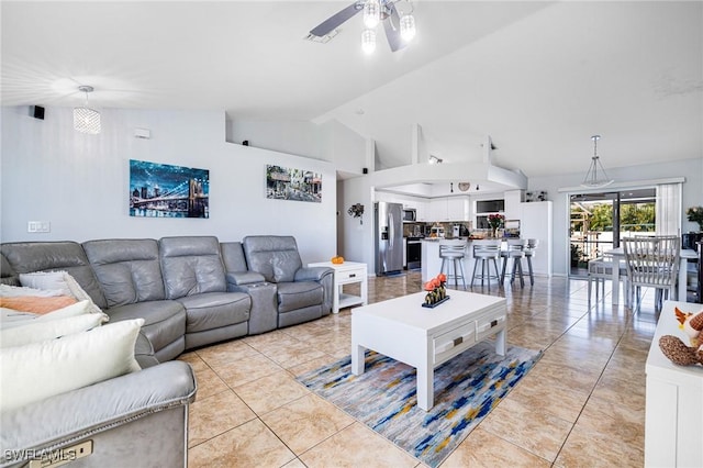 tiled living room with ceiling fan and high vaulted ceiling